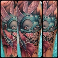 Funny designed cartoon like evil dragonfly tattoo on forearm with flower