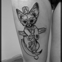 Funny looking black and white thigh tattoo of mystical cat with cross