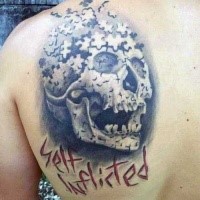 Lustig aussehendes schwarzes Schulter Tattoo mit Puzzle Bild und menschlichem Schädel und Schriftzug