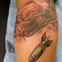 Funny looking colored leg tattoo of bomber plane and big bomb
