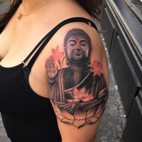 Funny looking colored shoulder tattoo of Buddha statue with flowers