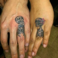Lustige Mann und Frau Skelette romantisches Paar farbige Tattoos an Ringfingern