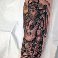 Lustig gemalter schwarzer und weißer Wikinger-Krieger spielt die Gitarre Tattoo am Arm
