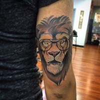 Tatuaje en el brazo, león magnífico en gafas