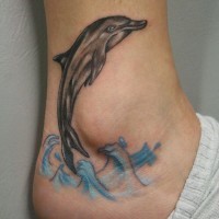 Funny painted little dolphin in waves tattoo on ankle