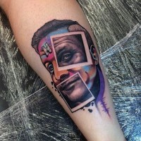 Tatuaje en el antebrazo, cara de hombre multicolor con fotos grises