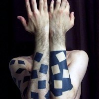 Tatuaje en el antebrazo,
 cuadrados diverentes de colores negro y blanco