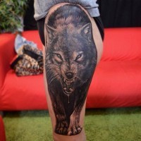 Tatuaje en el muslo,  lobo grande amenazante que caza