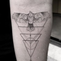 Geometrical style big black and white bird with figures tattoo on arm