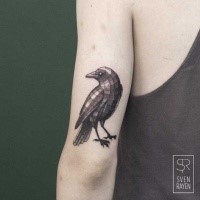 Geometrical style colored arm tattoo of small bird