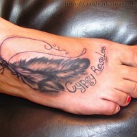 due piume  disegno con scritto tatuaggio su piedi di ragazza