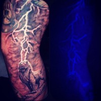 Herrlicher schwarzer und weißer Löwe mit Blitz aus leuchtenden Tinte Tattoo am Ärmel