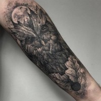 Tatuaje en el antebrazo,
lechuza divina con hojas y luna