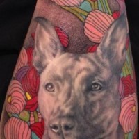 Gorgeous real photo like colored dog portrait tattoo on forearm stylized with flowers