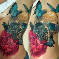 Gorgeous very detailed and colored human skull tattoo on side with flower and butterflies