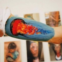 Tatuaje en el brazo, medusa de color ardiente
