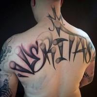Graffiti style colored upper back tattoo of lettering