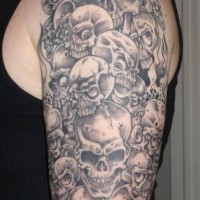 Gray ink a lot of skulls tattoo on half sleeve