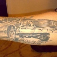 Gray ink car forearm tattoo