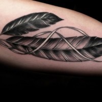 Gray-ink eagle feathers with ribbon tattoo on upper arm