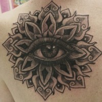 Tatuaje en el hombro, mandala gris oscura con ojo tremendo en el centro