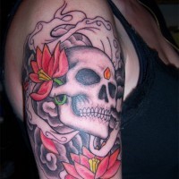 Gray skull with red flowers tattoo on shoulder