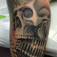 Gray washed colored arm tattoo of human skull with microphone