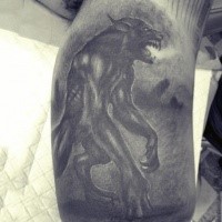 Gray washed detailed biceps tattoo of large werewolf