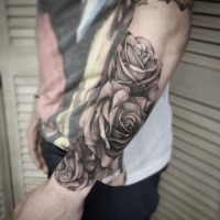 Gray washed style big realistic looking roses tattoo on forearm