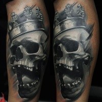 Gray washed style black and white leg tattoo of human skull with crown