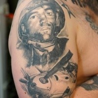Gray washed style black ink shoulder tattoo of WW2 soldier with plane
