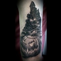 Gray washed style detailed creepy house with pumpkins field tattoo on forearm