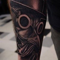 Gray washed style detailed forearm tattoo of plague doctors mask