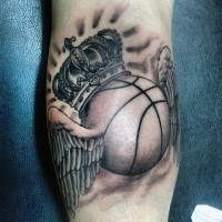 Gray washed style leg tattoo of basketball with wings and crown