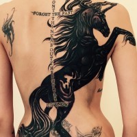 Tatuaje en la espalda,
unicornio negro fantástico y inscripción