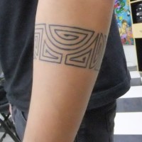 Großartiges geometrisches graues Tattoo von Armband in Tusche am Unterarm