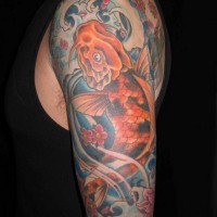 Great golden fish in ocean tattoo on upper arm