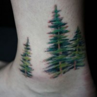 Tattoo mit grünen Fichten am Fuß
