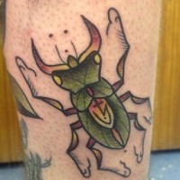 Green stag beetle with a sign on wings tattoo