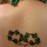 Tatuaje  de vid verde diminuta en la espalda
