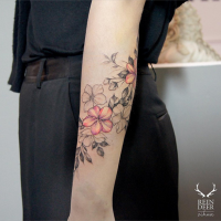 Half colored painted by Zihwa forearm tattoo of nice flowers