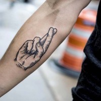 Hand with crossed fingers forearm tattoo