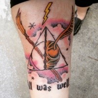 Harry Potter movie the,ed colored forearm tattoo of quiddich ball with lettering