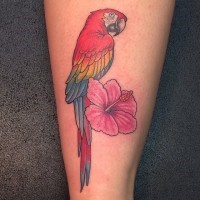 Hawaiian motifs tattoo on leg red rainbow colored macaw parrot and pink hibiscus flower