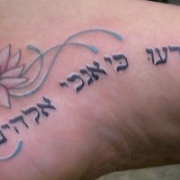 tatuaje en el pie de escritos hebreos con flor de loto