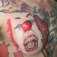 Hideous clown face tattoo on chest