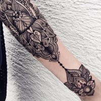 Hinduism style black ink arm tattoo of various ornaments