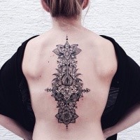 Hinduism style black ink back tattoo of various ornamental flowers