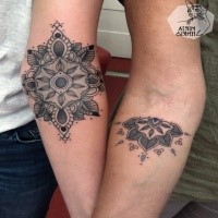 Hinduism style black ink forearm tattoo of small flowers