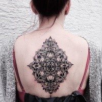 Hinduism style black ink whole back tattoo of beautiful flower